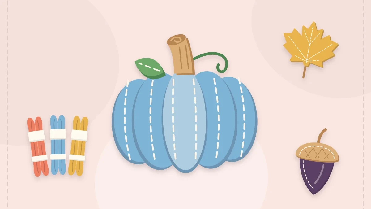 Stuffed felt pumpkin with an autumn leaf, acorn and embroidery floss skeins